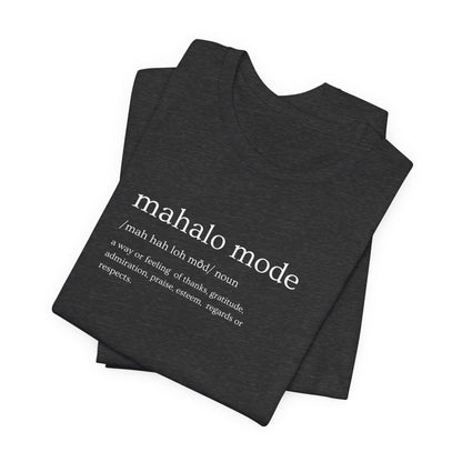 A folded dark charcoal gray heather t-shirt with a white printed dictionary-style definition of 'mahalo mode' on the chest, shown against a plain white background.