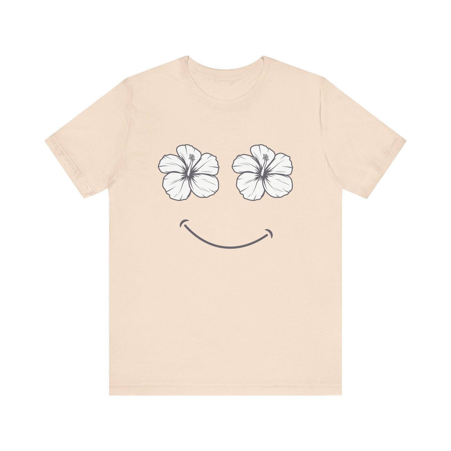 A light beige crewneck t-shirt featuring a graphic of two white hibiscus flowers forming eyes and a simple smile on the front, displayed against a solid white background.