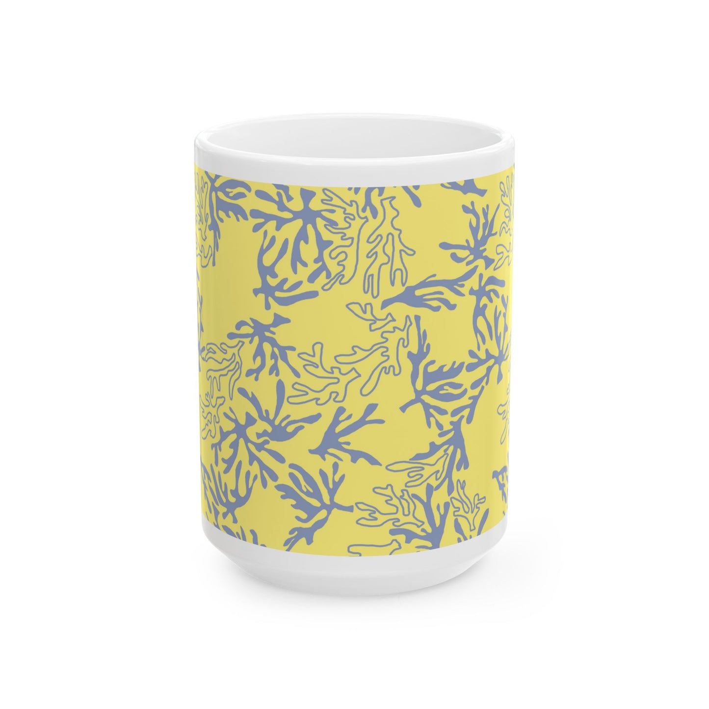 A white ceramic mug featuring a yellow wrap-around sleeve with a blue coral pattern, shown on a clean white background.