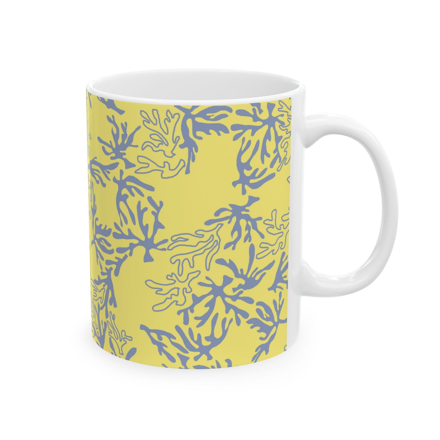 A white ceramic mug featuring a yellow and blue coral pattern on the exterior, shown against a plain white background.