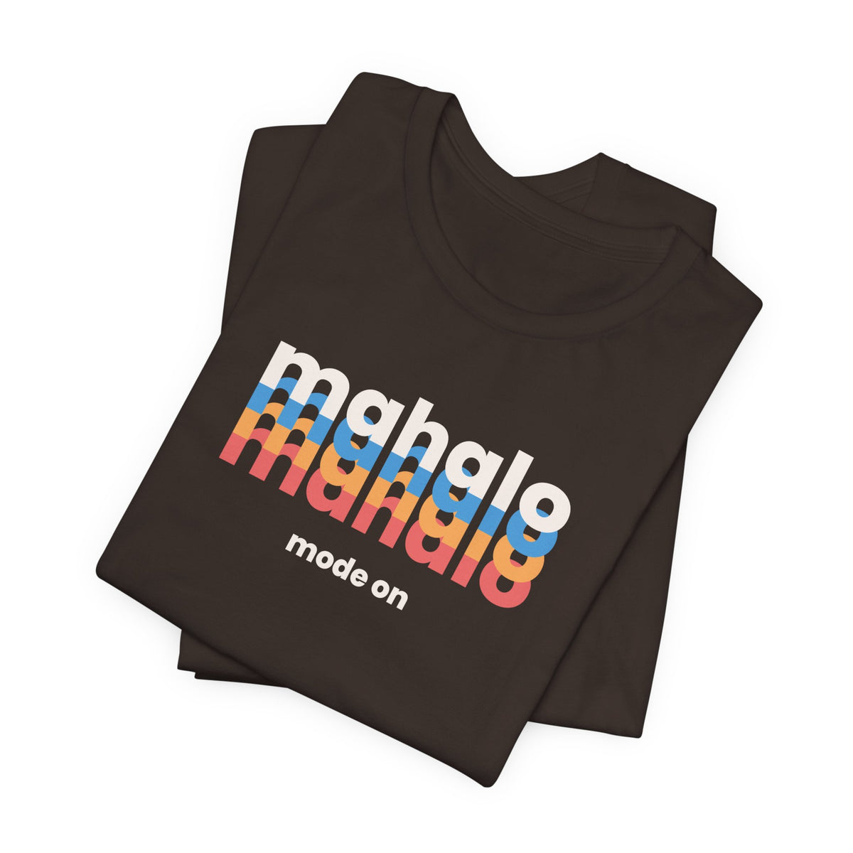 A folded dark brown t-shirt with a retro-style graphic reading 'mahalo mahalo' in white, blue, orange, and red gradient letters, with 'mode on' printed below in white, on a clean white background.