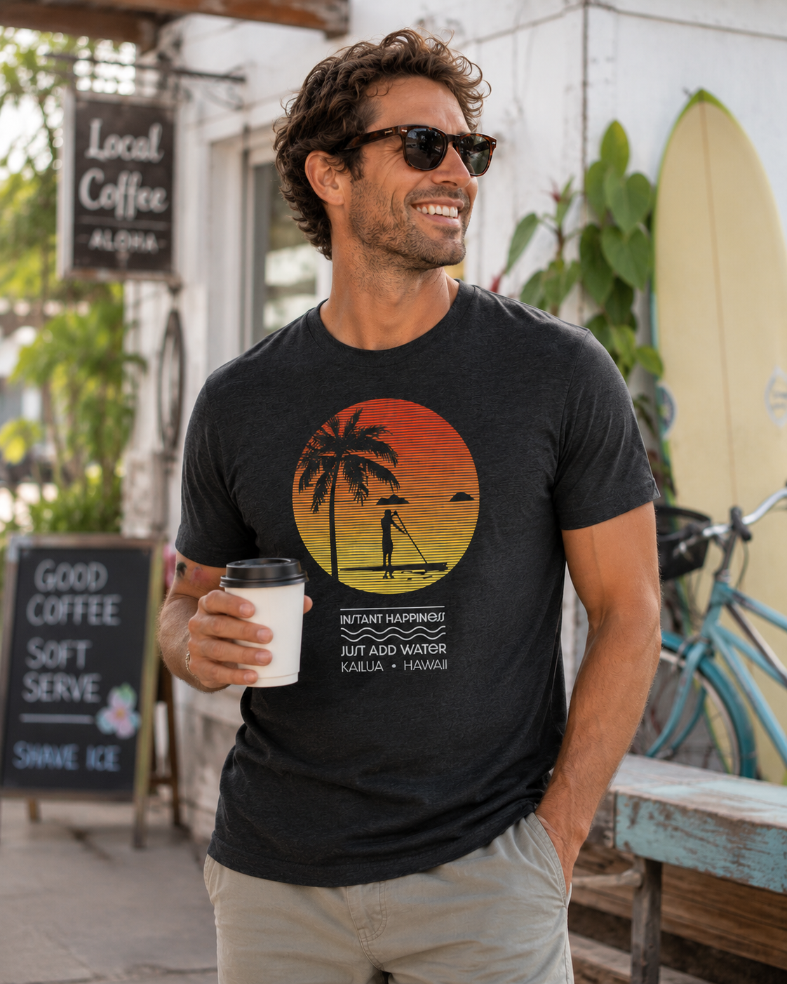 Man wearing the Instant Happiness Paddleboard Triblend Tee outside a beach café in Kailua, Hawaii.
