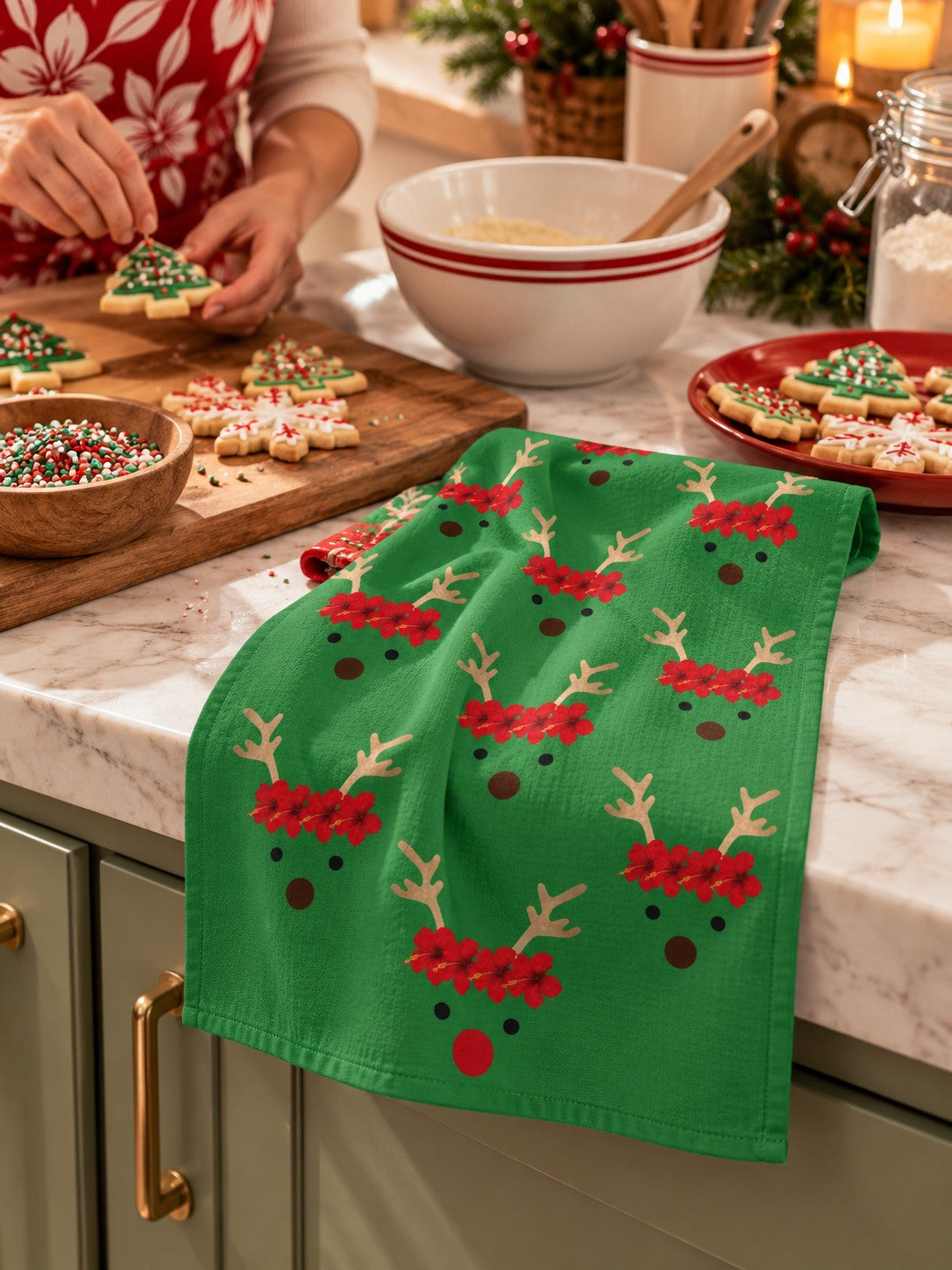 Reindeer Holiday Kitchen Towel — Green tropical reindeer kitchen towel resting naturally on a counter while Christmas cookies are decorated.