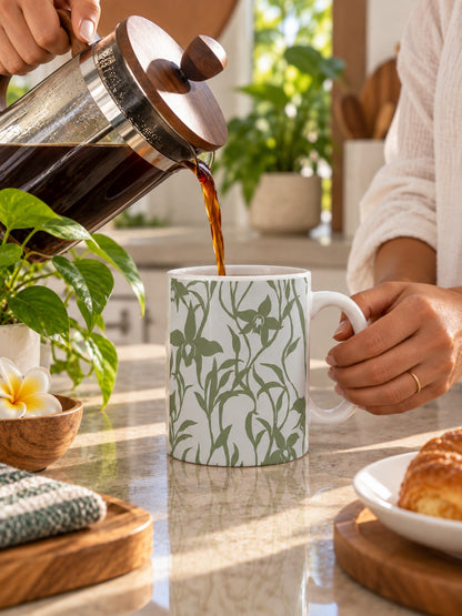 Coffee being poured into an Orchid Sage ceramic mug on a bright tropical kitchen counter.