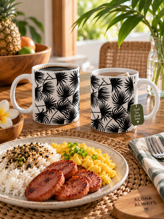 Two Palm Fan Black ceramic mugs with coffee and tea beside a local-style breakfast of eggs, rice and Portuguese sausage.