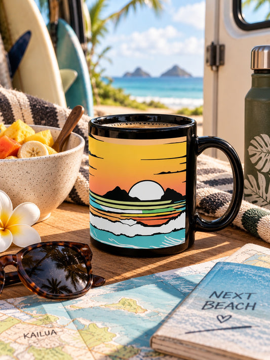 Summer Sunrise black coffee mug with colorful ocean artwork beside beach gear overlooking the water in Kailua, Hawaiʻi.