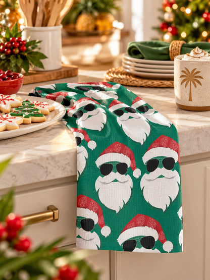 Green tropical Santa kitchen towel beside Christmas cookies and milk in a festive holiday setting.
