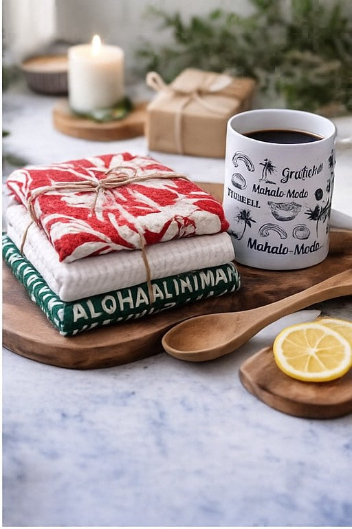 stacked hawaii holiday kitchen towels displayed with hawaii mahalo mug and wooden cutting board