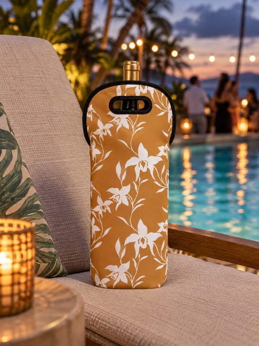 Caramel insulated wine tote with a white orchid print resting on a pool lounge chair at an evening party.