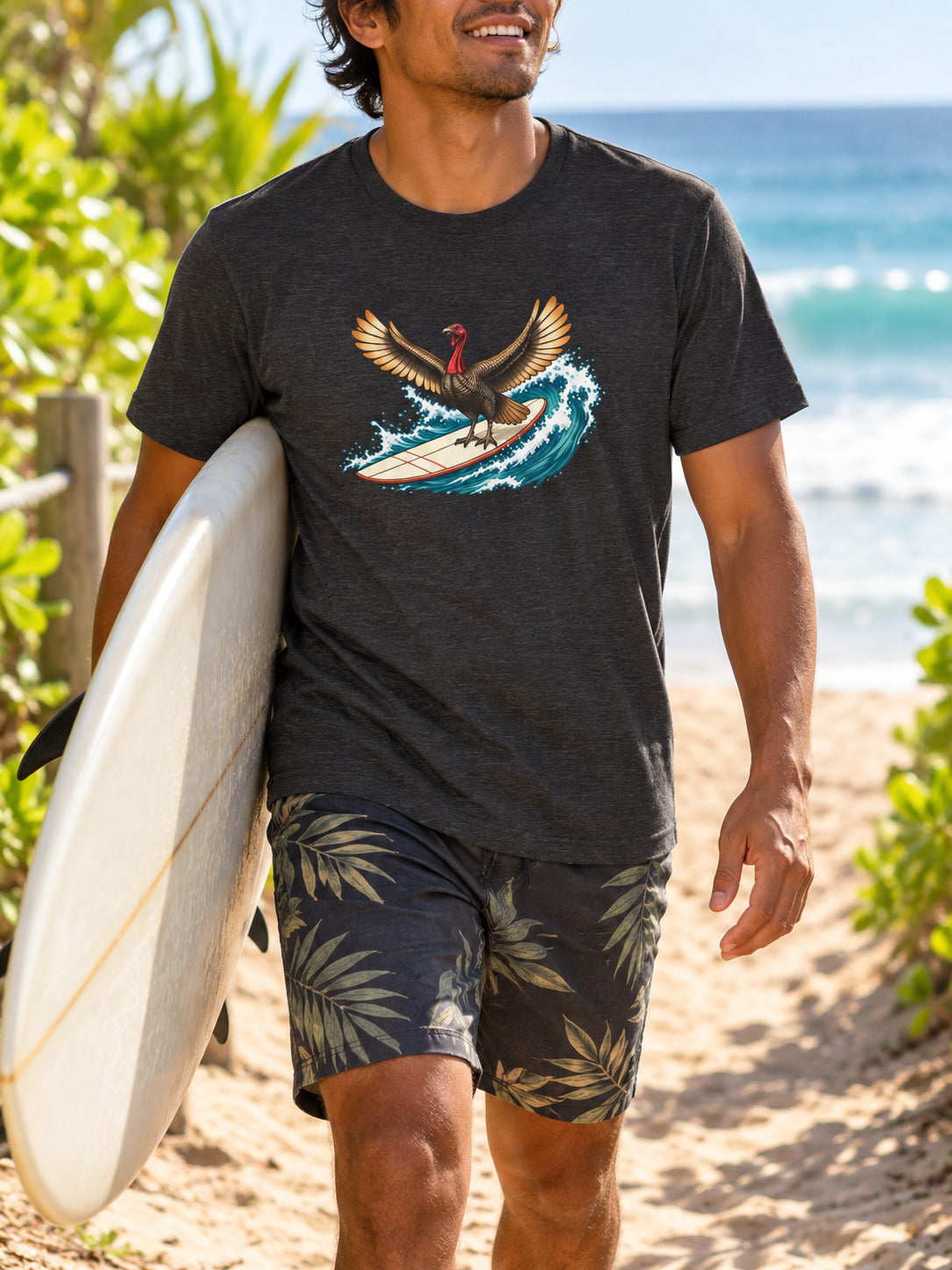 Hawaiian man carrying a surfboard to the beach in a dark gray surfing turkey Thanksgiving T-shirt.